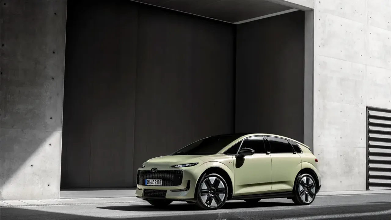 Elettronauti - Audi A2 e-tron verde chiaro vista di lato davanti a un edificio in cemento