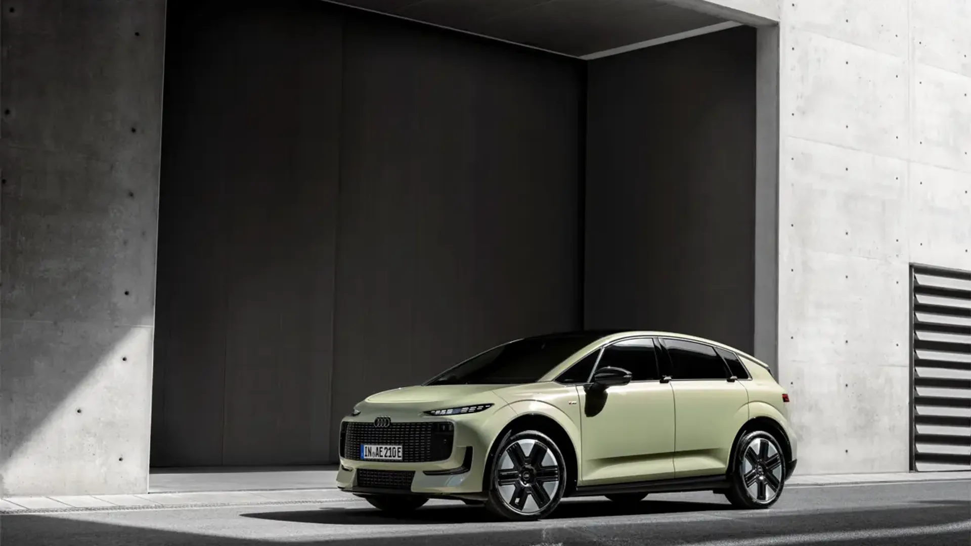 Elettronauti - Audi A2 e-tron verde chiaro vista di lato davanti a un edificio in cemento