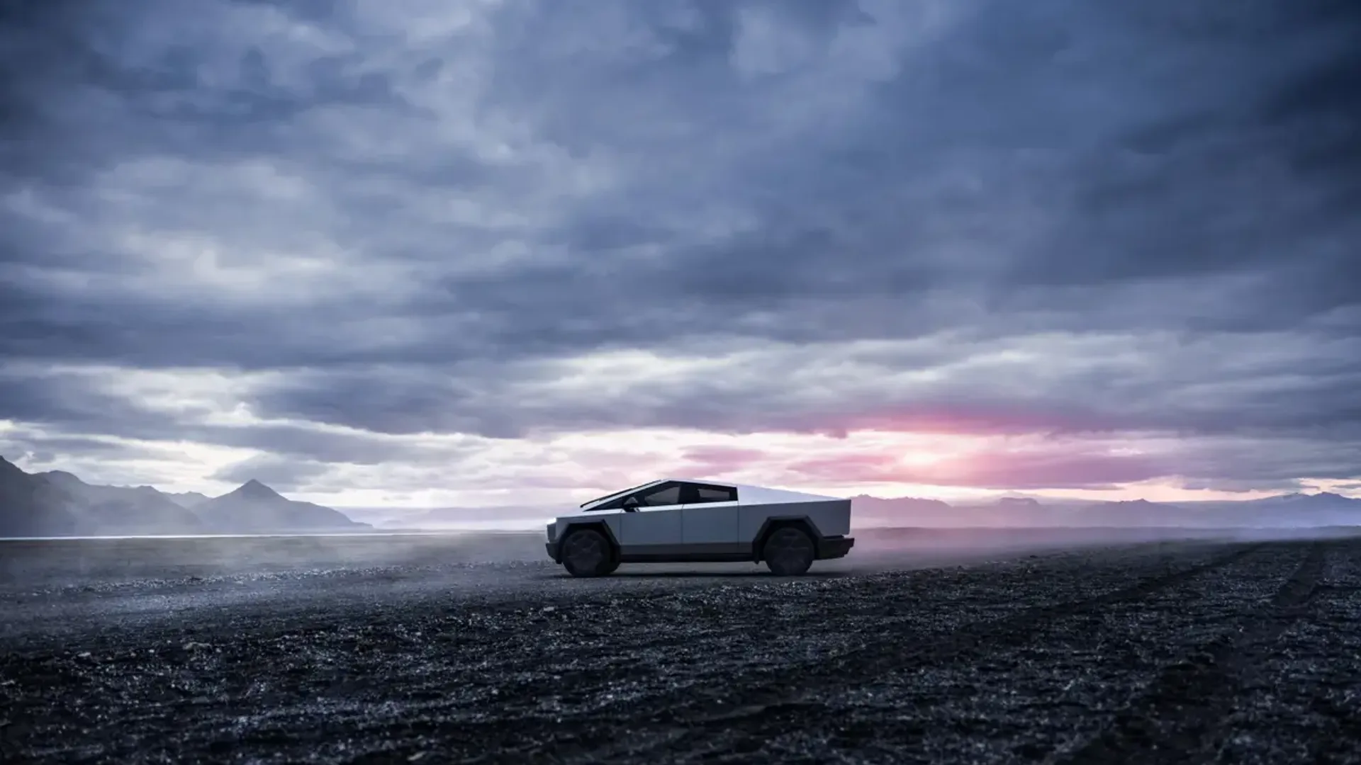Elettronauti - Tesla Cybertruck argento vista di lato su una pianura rocciosa scura