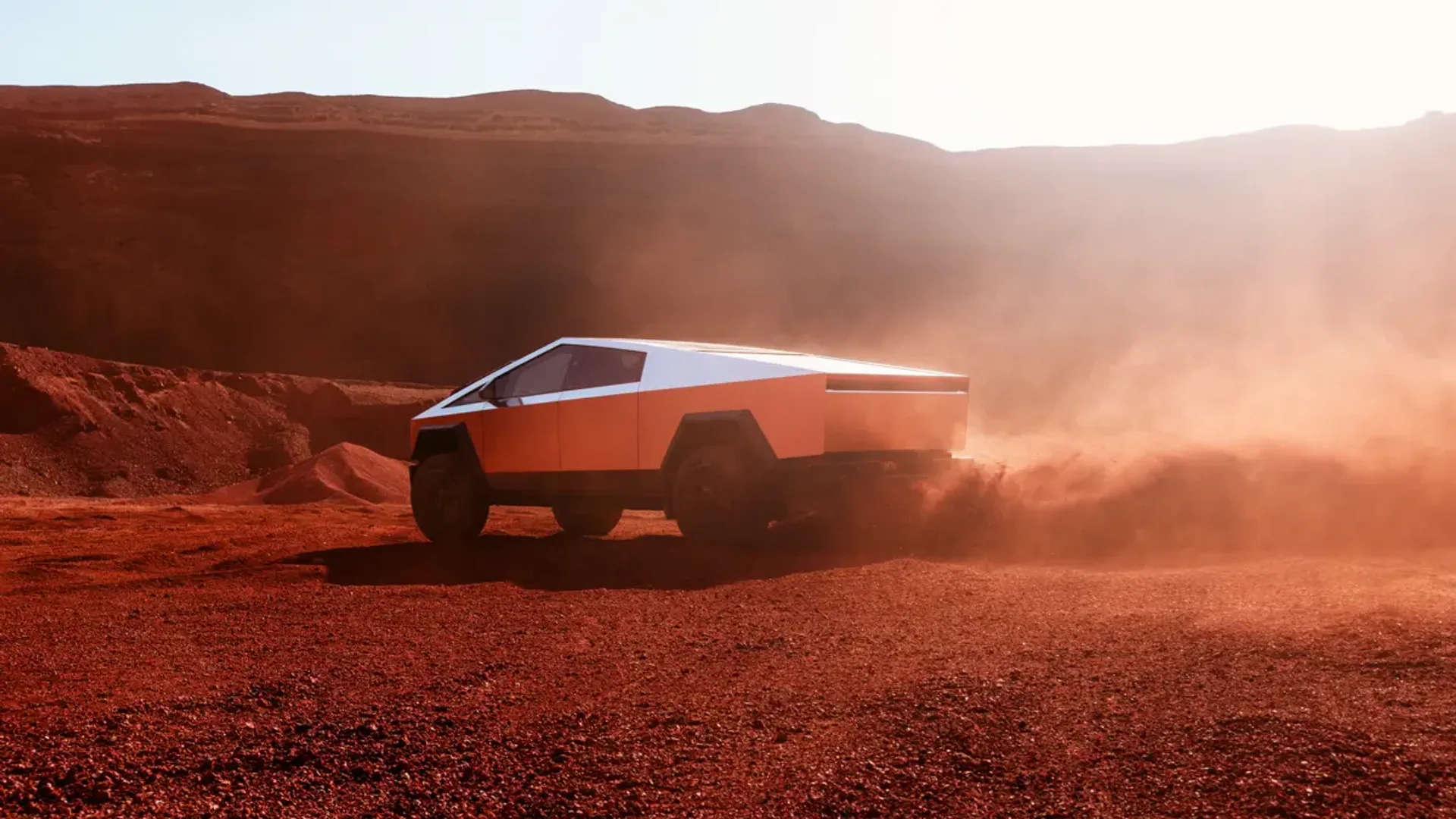 Elettronauti - Tesla Cybertruck argento in vista posteriore di tre quarti su terreno desertico rosso
