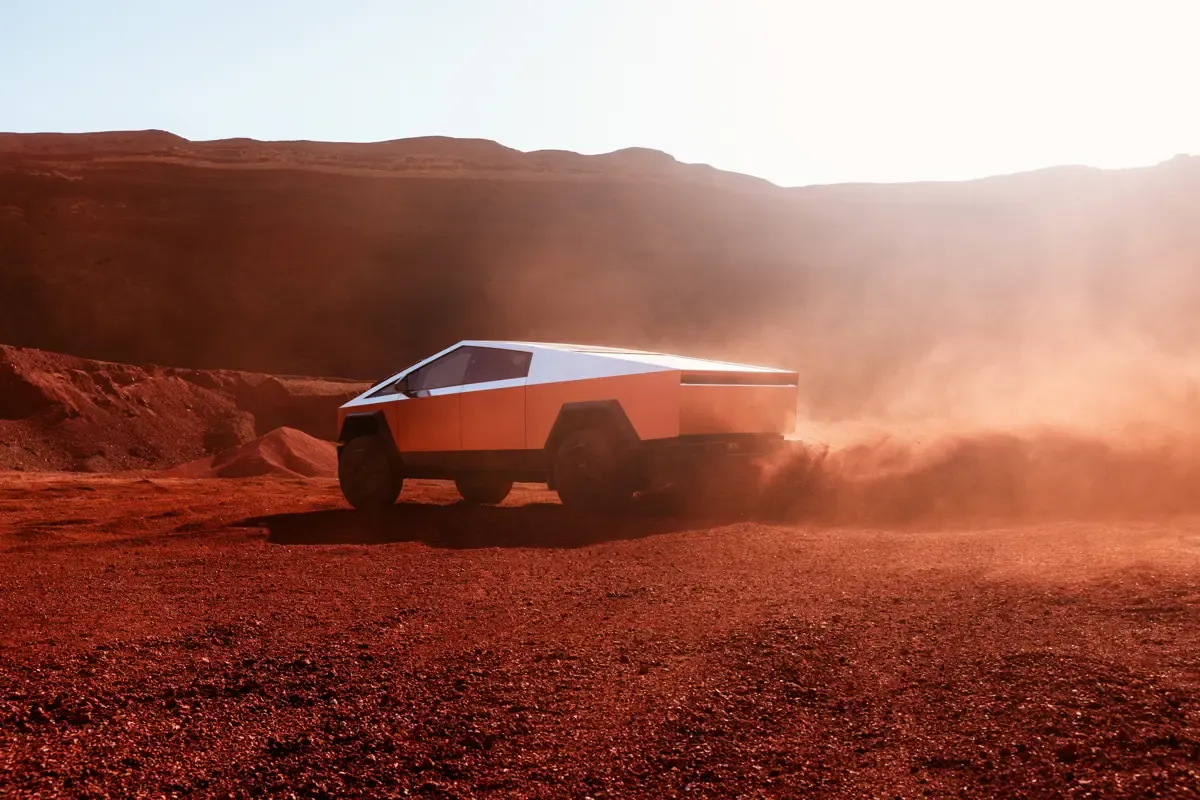 Elettronauti - Tesla Cybertruck argento in vista posteriore di tre quarti su terreno desertico rosso