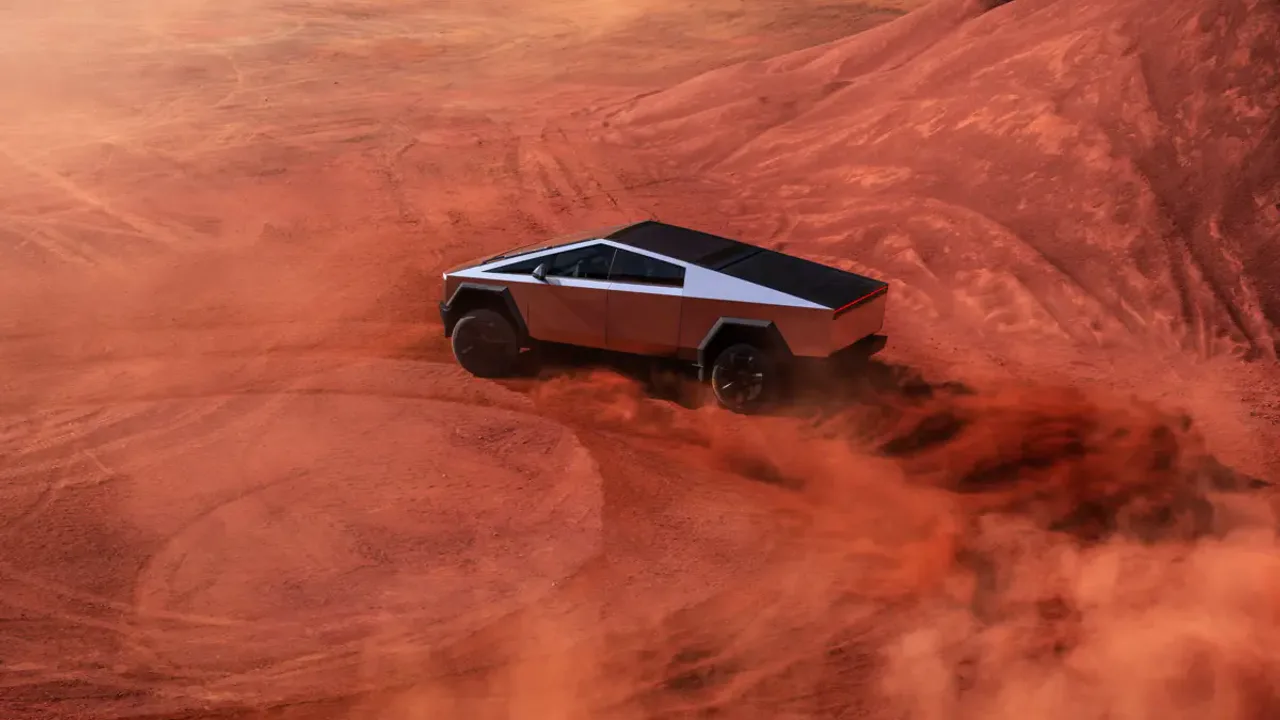 Elettronauti - Tesla Cybertruck argento in vista posteriore di tre quarti tra polvere rossa