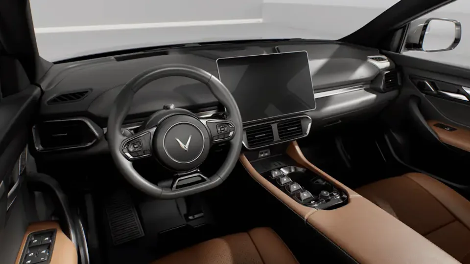 Elettronauti - Plancia della VinFast VF 8 con touchscreen centrale, volante e rivestimenti interni marroni.